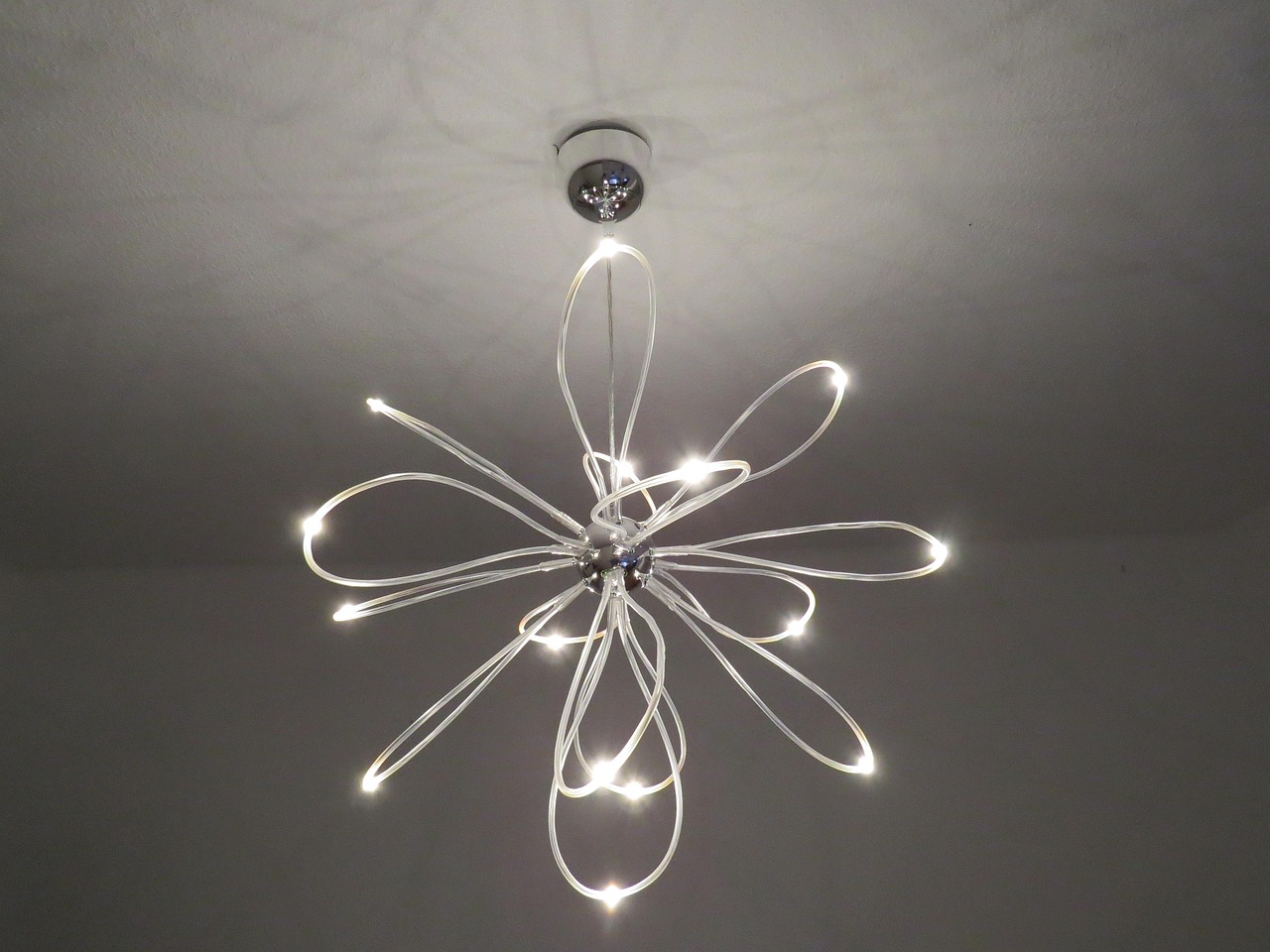 Nowoczesna lampa sufitowa z diodami LED w kształcie kwiatu oświetlająca wnętrze domu.